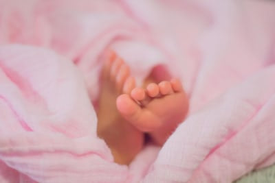 baby's feet wrapped in a pink blanket