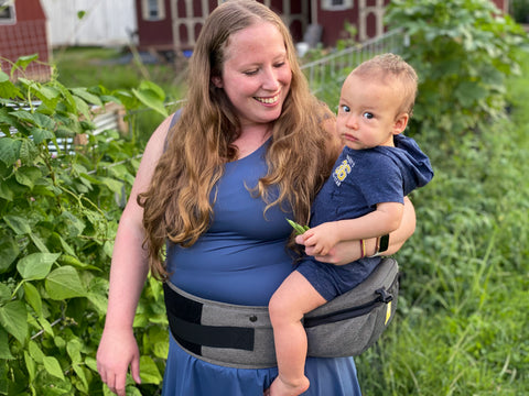 Mother wearing child in LILLEbaby SeatMe Hip Seat carrier