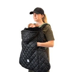 Woman wearing baby carrier with 7 am enfant carrier cover