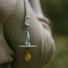 BIBs pacifier in natural rubber hanging from a pacifier clip