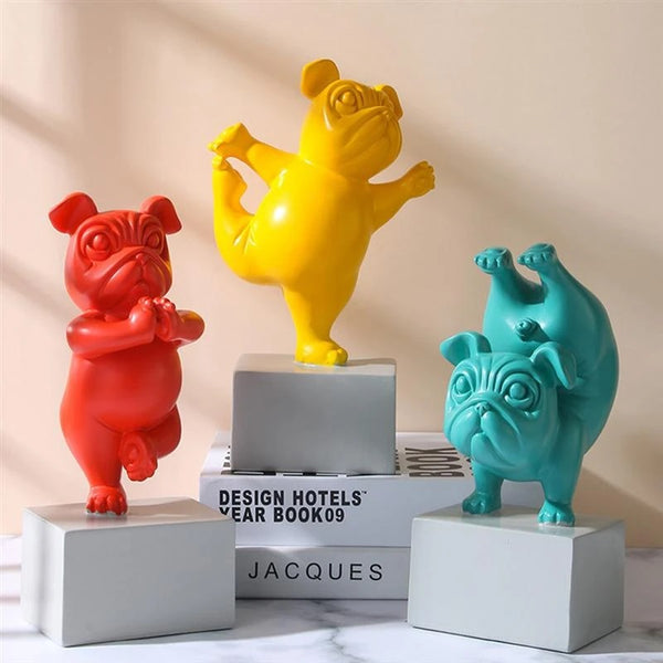 Image of three Pug statues doing yoga in yellow, teal and red color, made of resin