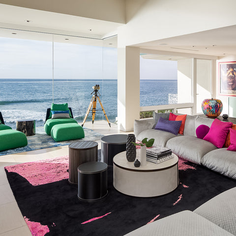 Black and pink Christopher Fareed rug in a luxury living room with big window view of lake.