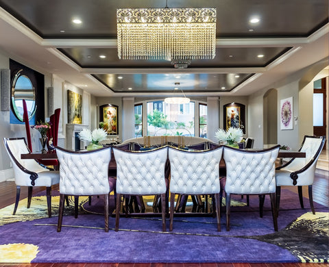 luxury dinning room with bright purple rug and a table with white chairs.