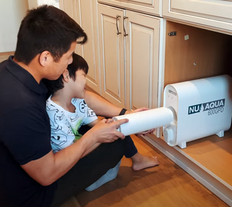 Father and son changing reverse osmosis filter