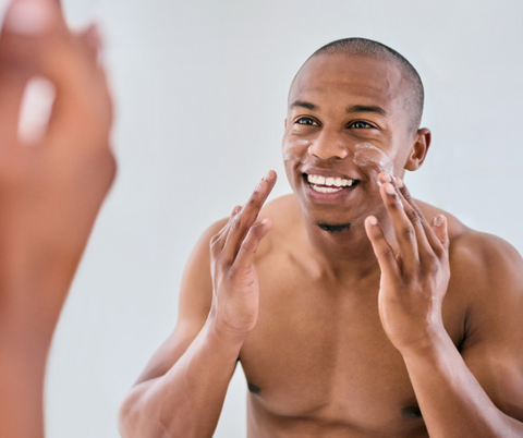 a guy moisturizing their face