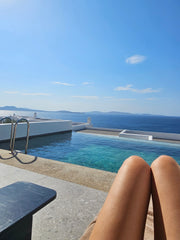Owner of Luna Swim lounges in her bikini bottom and bikini top at the resort in Mykonos, Greece.