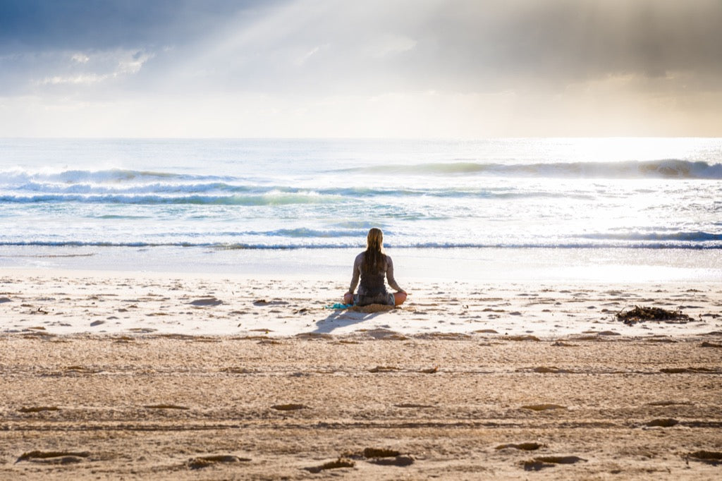 Woman doing yoga an the beach