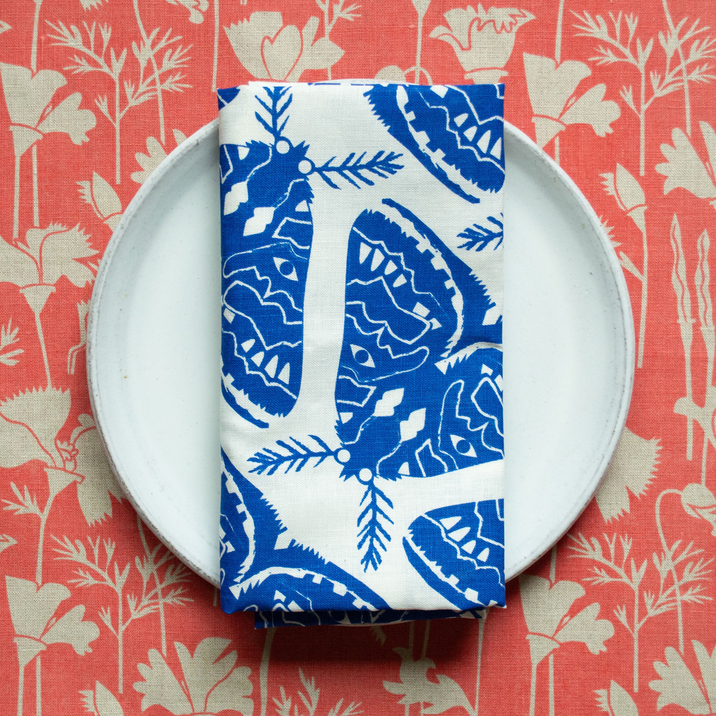 napkin printed with blue moths folded on a plate