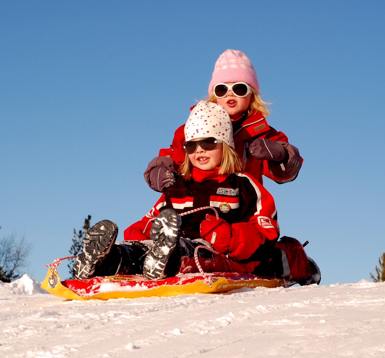 two kids sledding at a winter-themed birthday party