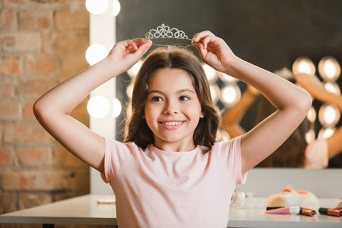 A beautiful girl holding a diamond crown on her head.