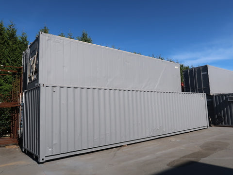 Refrigerated and non refrigerated shipping containers stacked on top of each other.