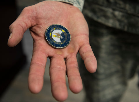 Hand holding a challenge coin