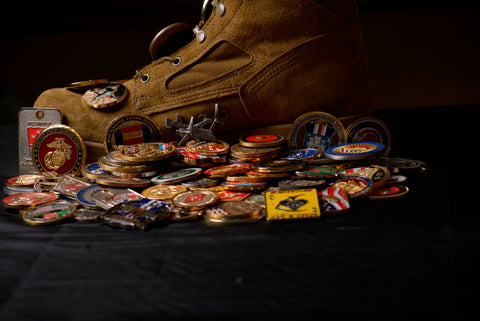 Pile of challenge coins and a military boot