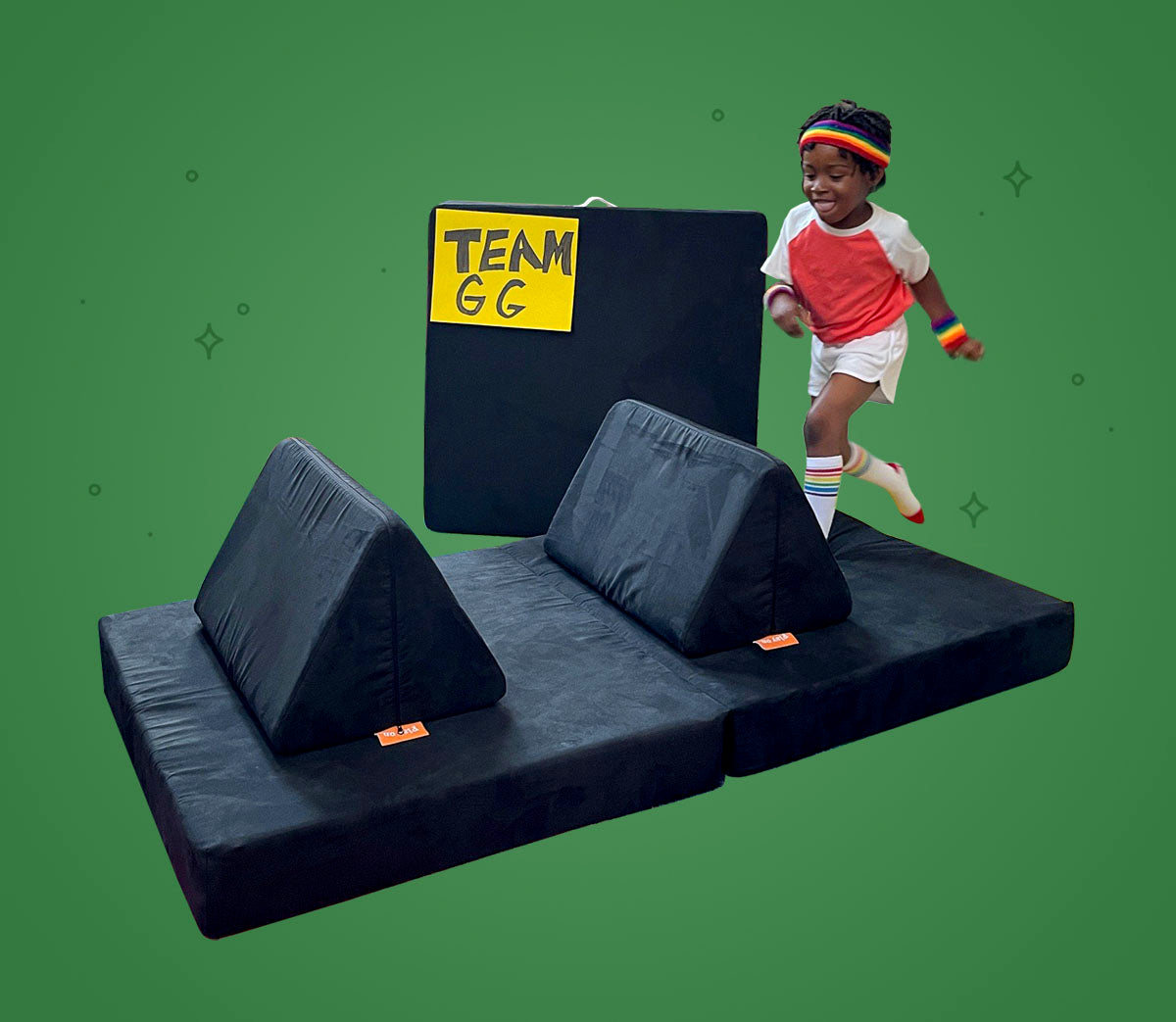 Child leaping over a pillow placed on cushion, set up like a hurdle from track and field