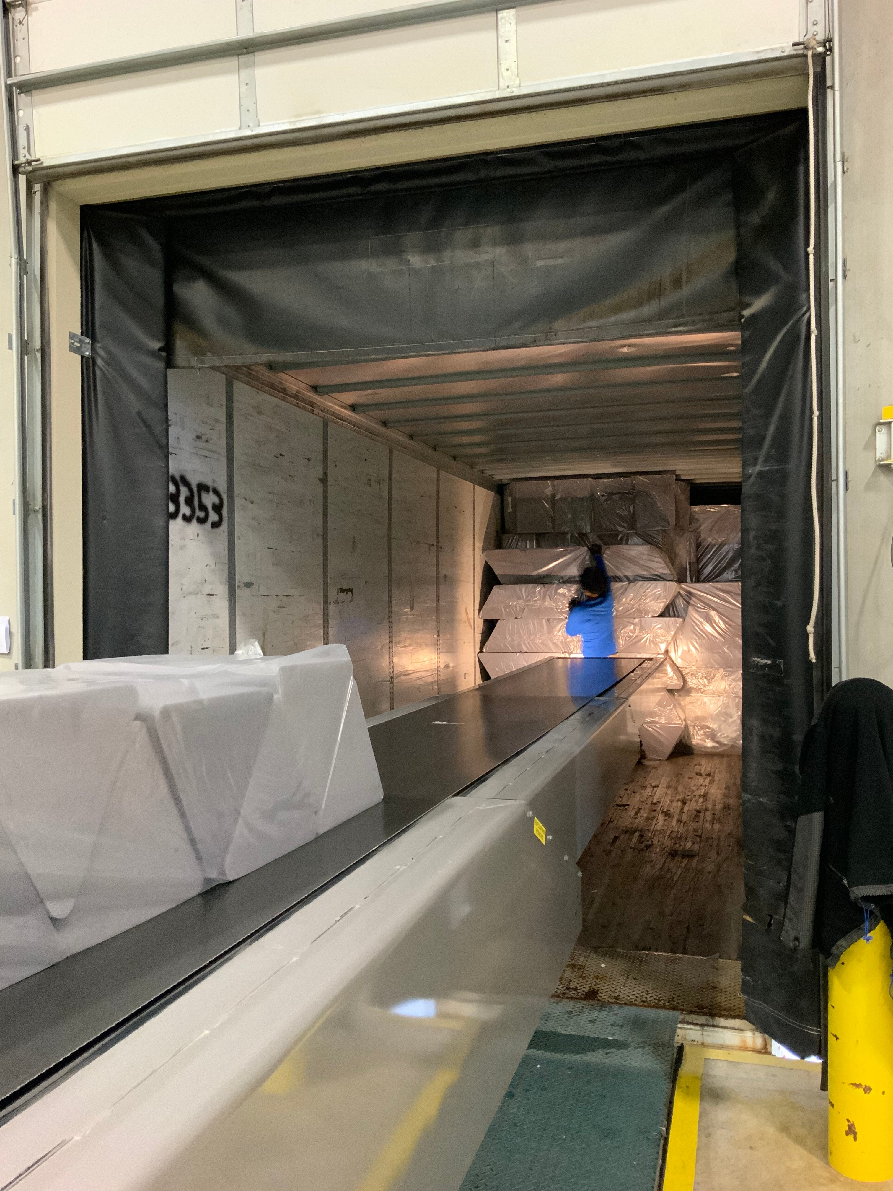 Nugget team member unloading foam from truck onto extendable conveyer belt