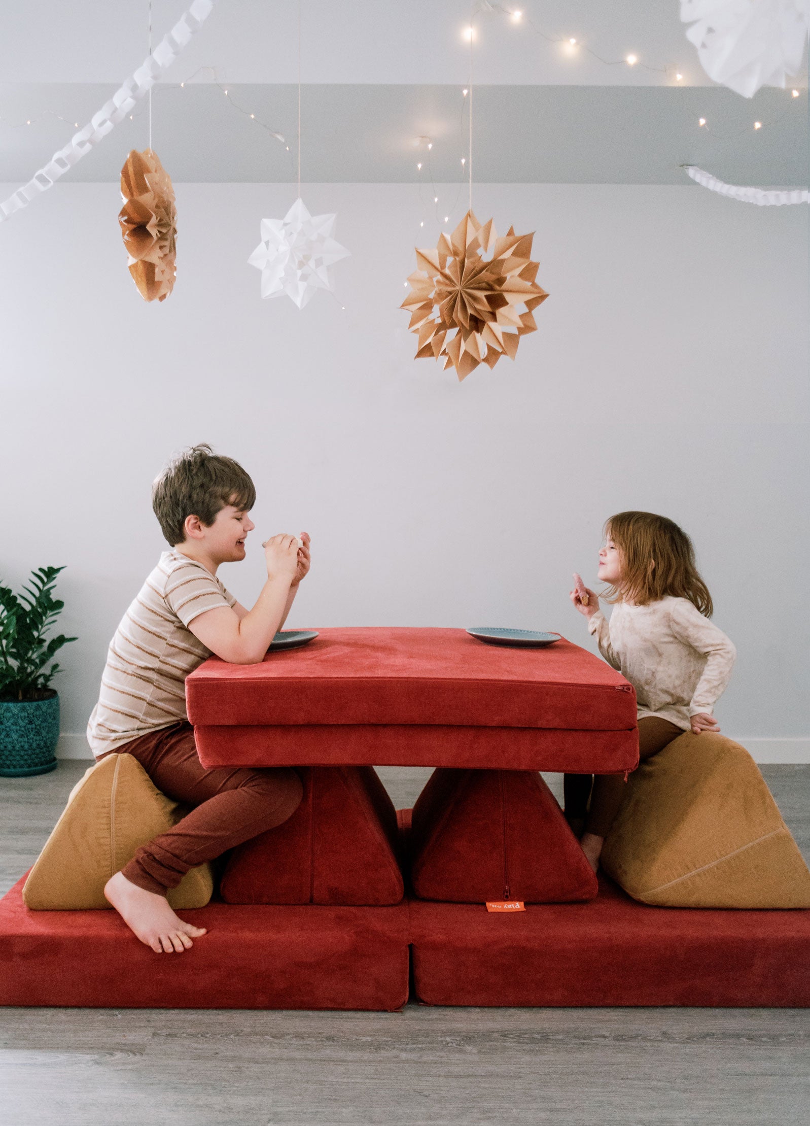 Two kids sit at a "Nugget table" while having a snack.