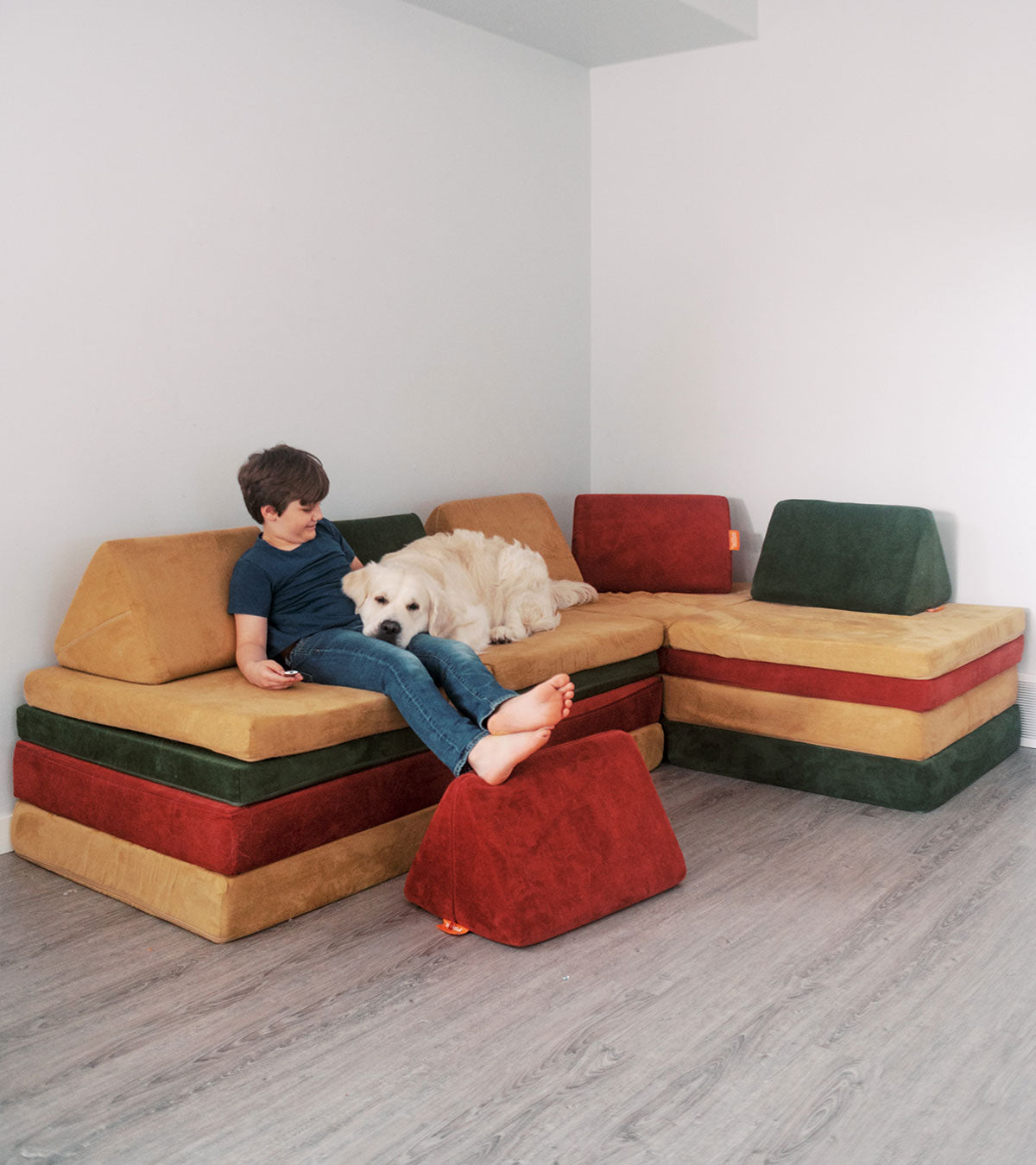 A child and a dog lounge on a Nugget "sectional" made up of four Nuggets.