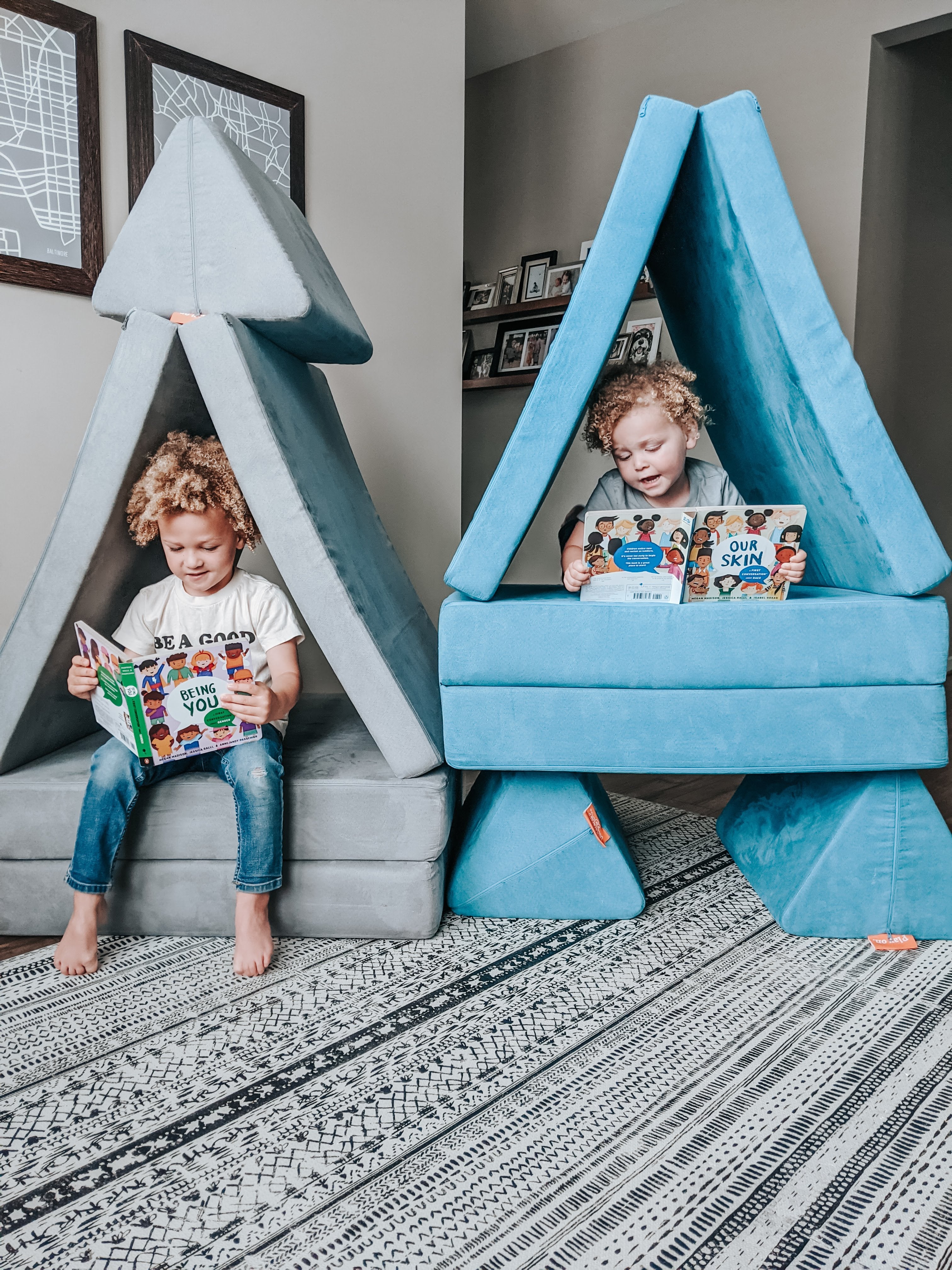 Two kids reading in their own Nugget forts