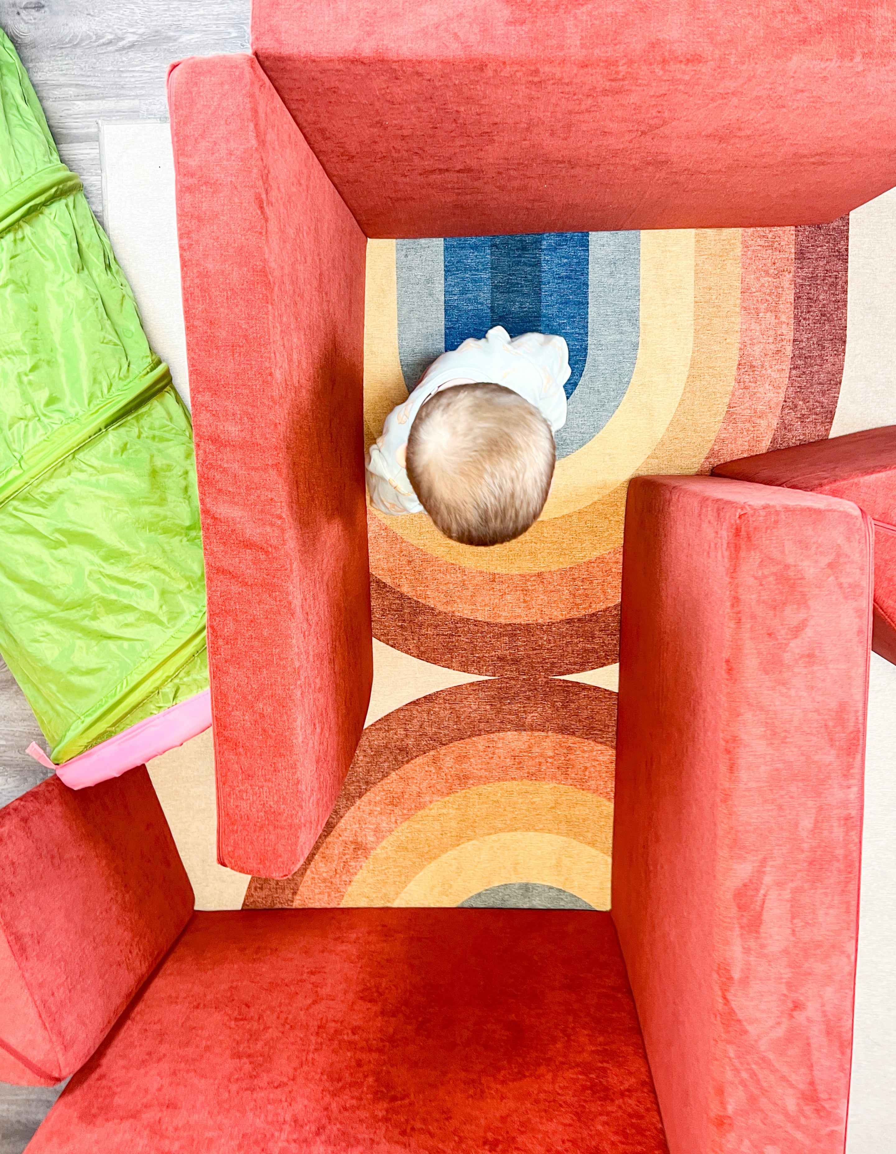 Nugget cushions placed vertically to create maze walls. A child walks through the maze towards a bright green tunnel.