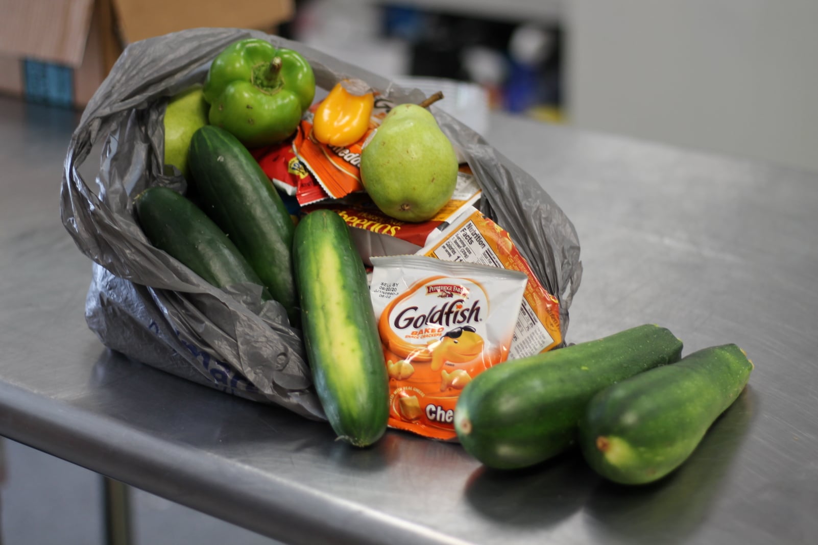Bag of food with packaged snacks and fresh produce