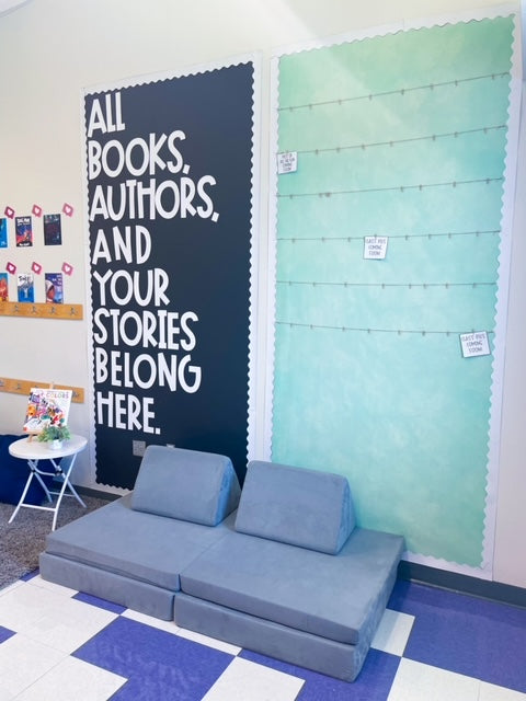 A gray Nugget in a classroom, with a sign on the wall behind that says "All books, authors, and your stories belong here."