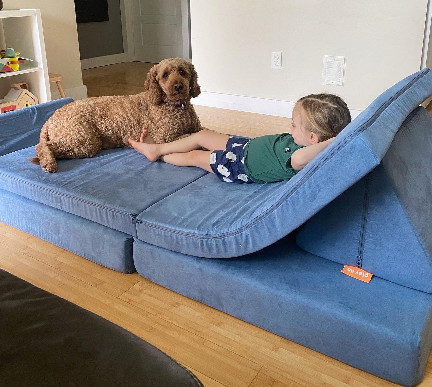 Child and dog lounging on a Nugget together