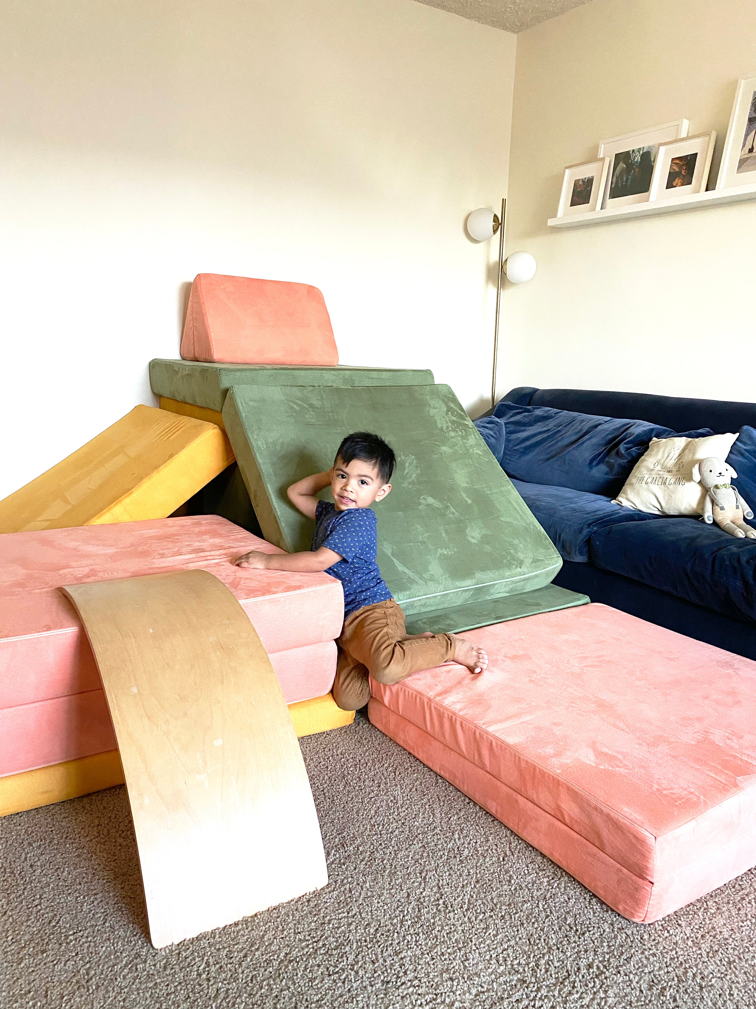 Child sitting on a three-Nugget build, with a slide, ramp to climb up, and lots of fun to be had