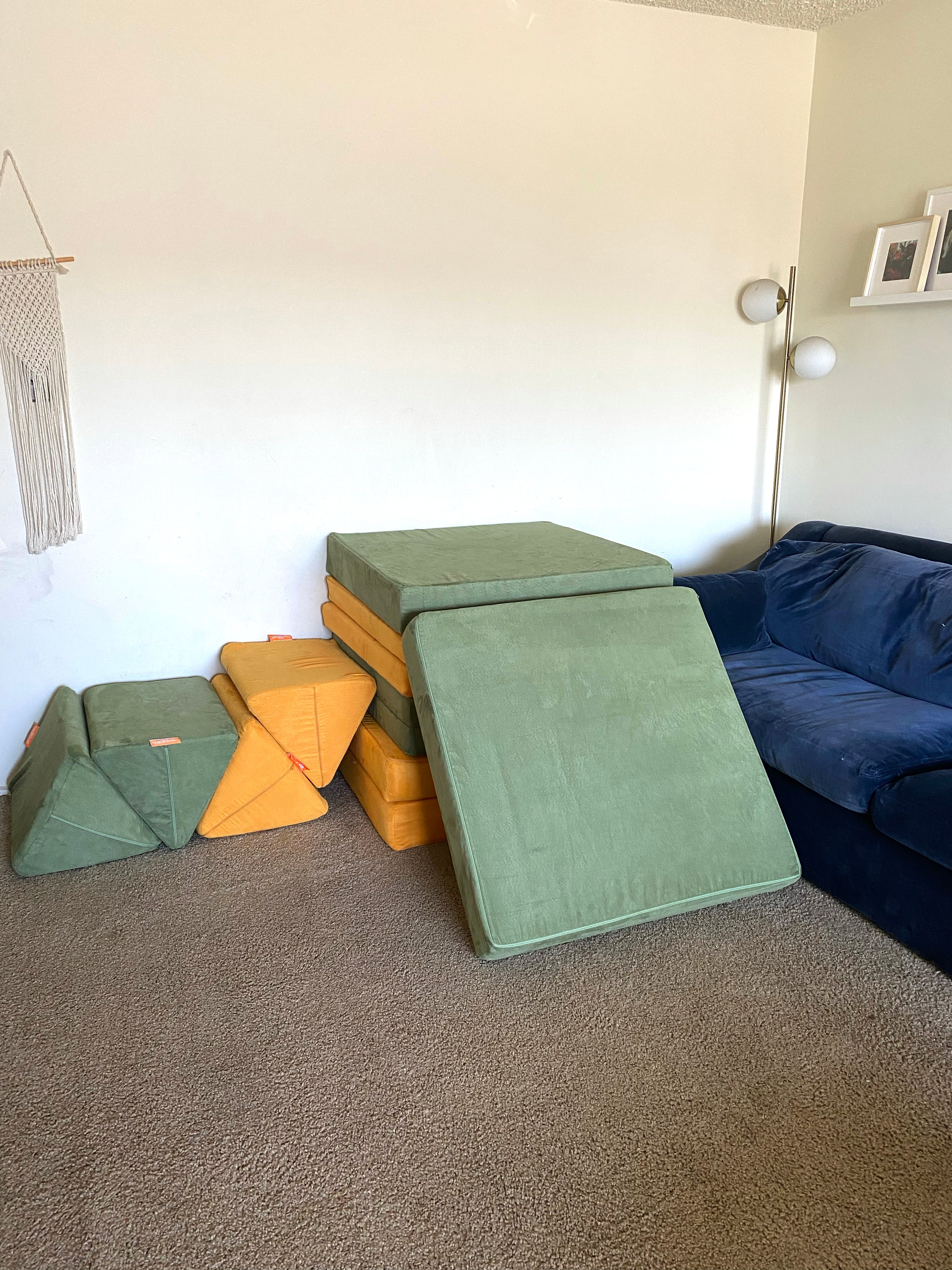 Pillows stacked as stairs up to a stack of Nugget cushions and bases, with one section open like a slide.