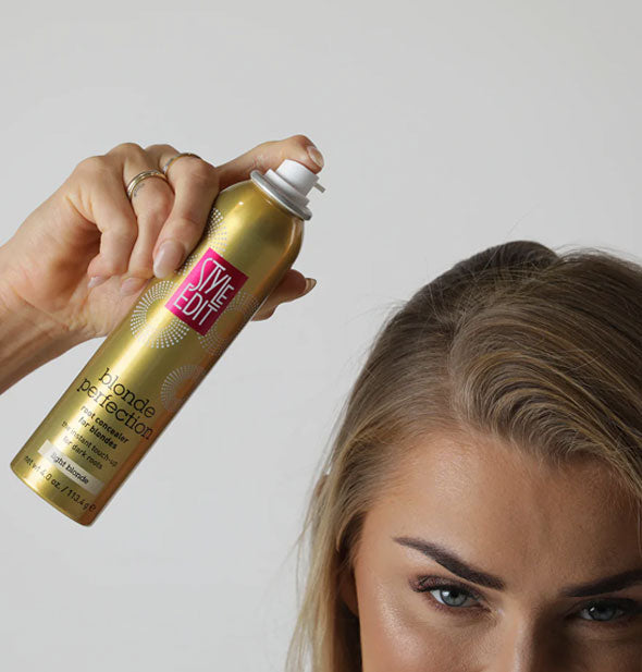 Model demonstrates application method and distance with a can of Style Edit Blonde Perfection Root Concealer