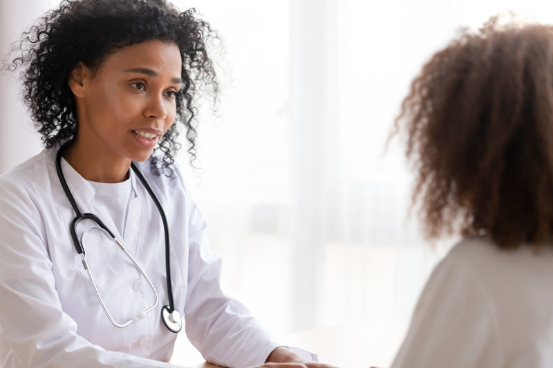 A black female doctor consults a young patient