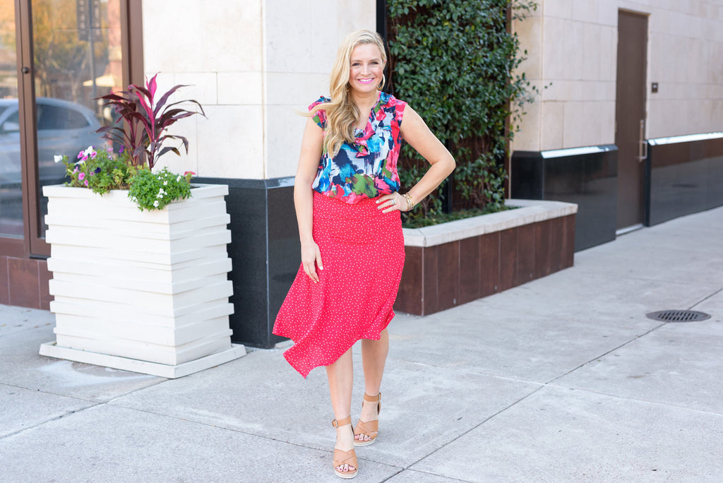 blogger Ashley Lastovica wearing asymmetrical floral skirt and pink ruffle cap sleeve blouse