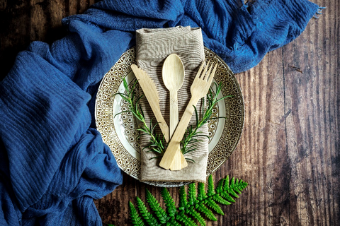 A plate covered with a napkin and bamboo cutlery.