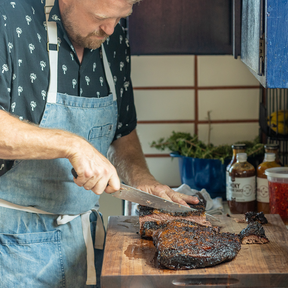 Chef Tim Hollingsworth cutting apart his Texas Style Brisket