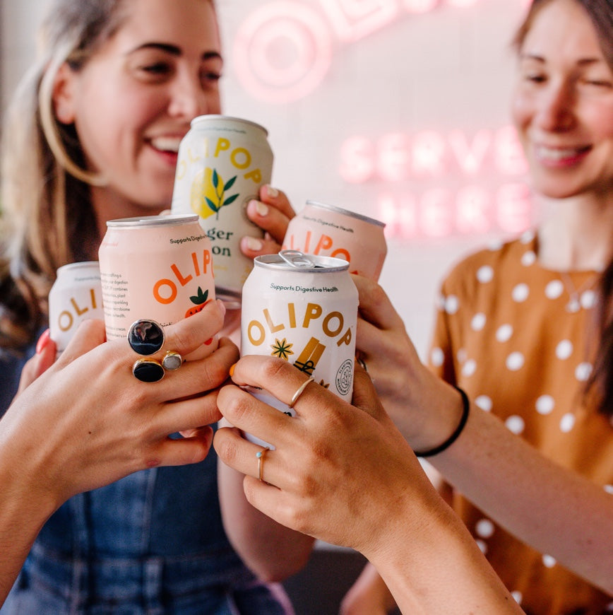 People cheers with Olipop cans