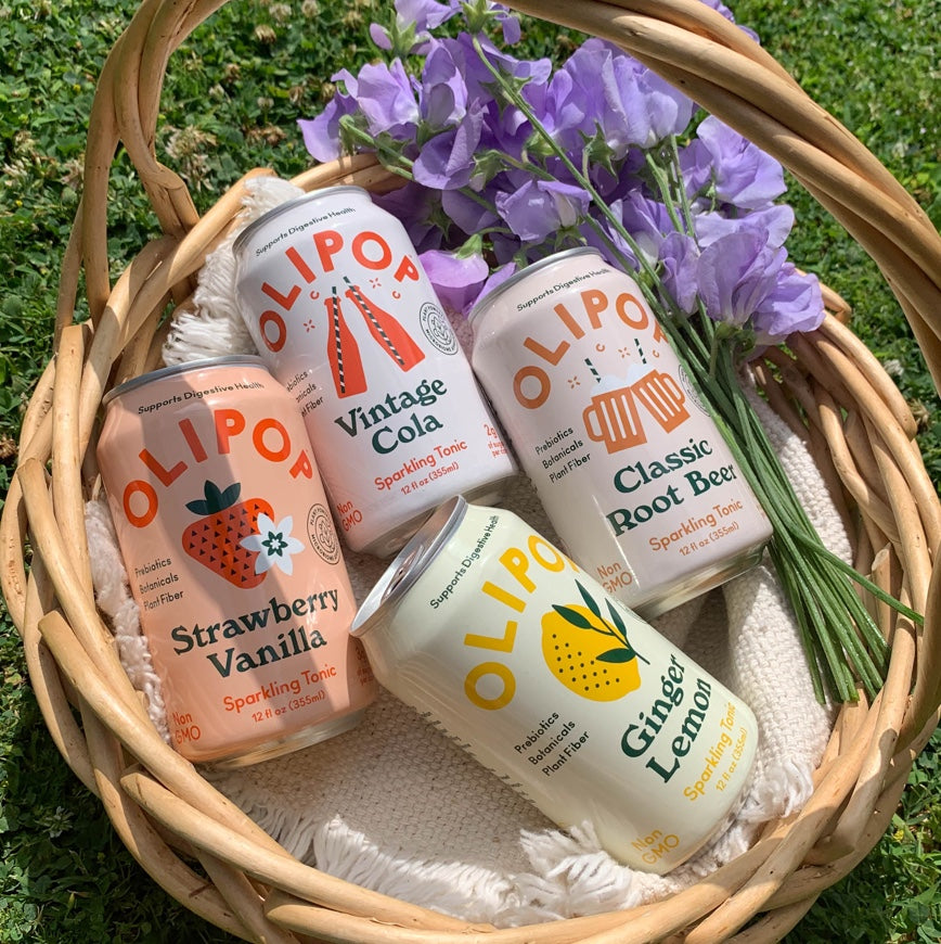 Wicker basket with Olipop cans and flowers inside