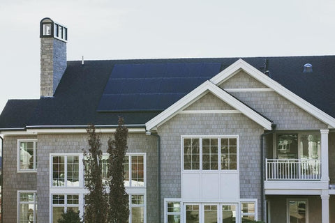 grey home with solar panels on black roof