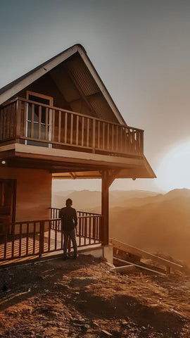 man standing at cabin on top of mountain