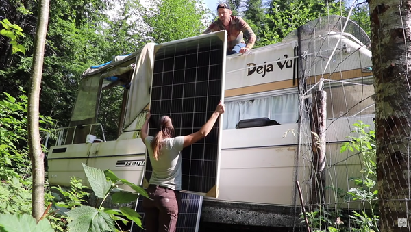 jake and nicole setting up a solar panel on a RV