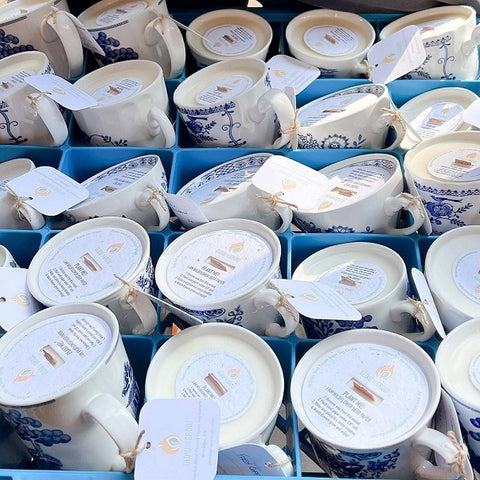 Vintage blue and white mug and teacup candles with protective dust covers made from wildflower seed paper.