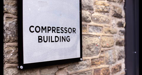 Compressor Building sign on a brick wall