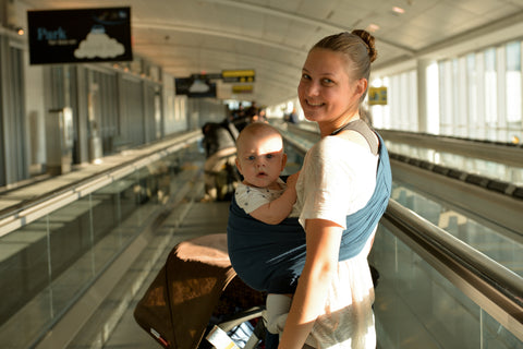 Infant in wrap-style carrier while traveling by air.