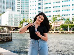 woman holding CBD Calm Tincture bottle in front of Miami river