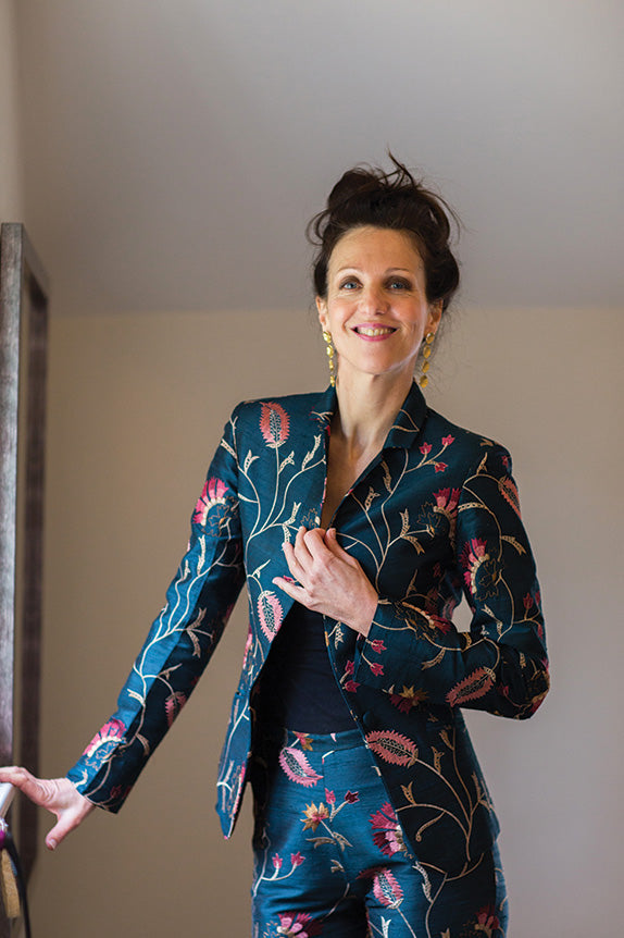 Woman with dark hair wears a deep teal silk suit in Mineral fabric