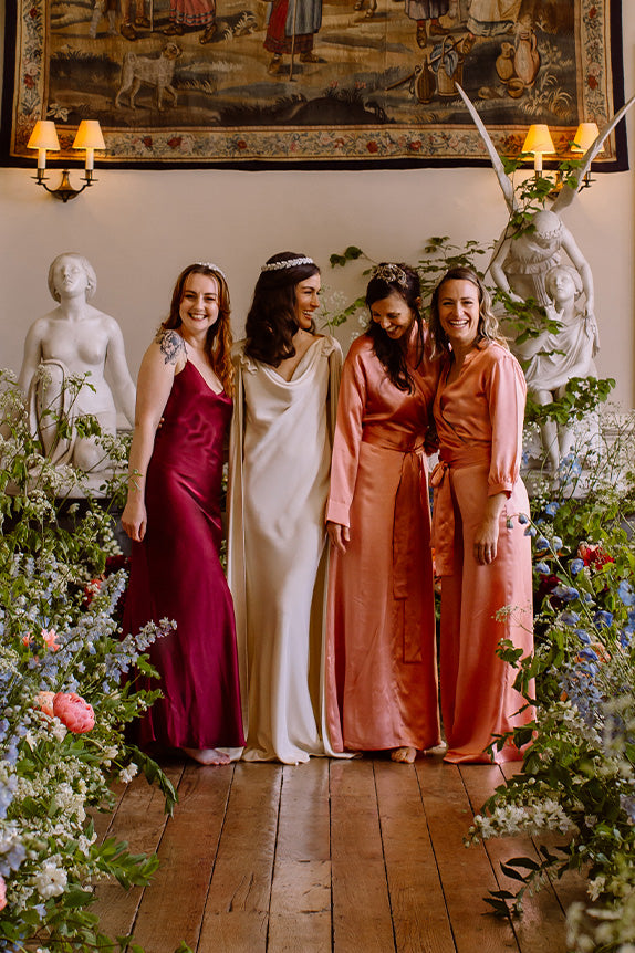 Bride with bridesmaids in silk bridesmaid jumpsuits and silk slip bridesmaid dress