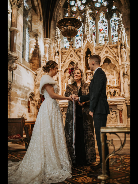 Mother of the bride at wedding ceremony wearing long coat.