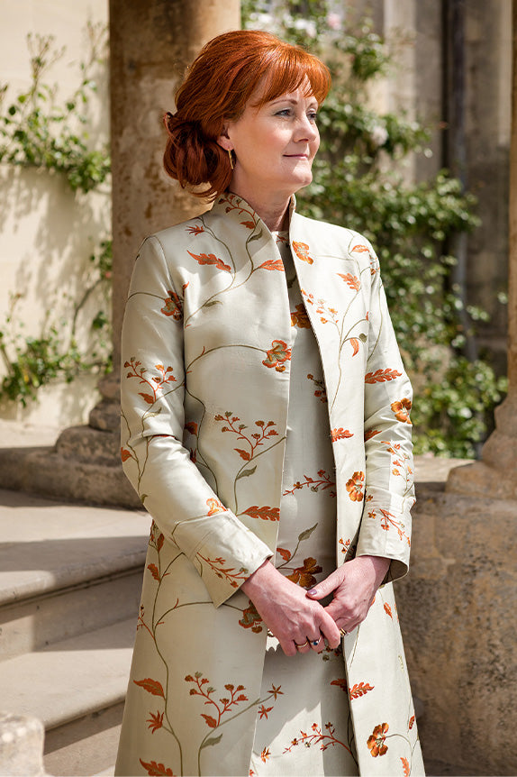 Mother of the bride, woman with red hair in silk dress and coat, shibumi lyra coat and hepburn dress in soft pistachio