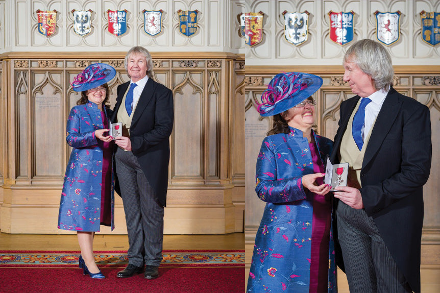 Couple at investiture. Woman wears special occasion outfit in pink silk dress and blue silk coat with matching hat. Silk Women's Nehru Coat in Vivid.