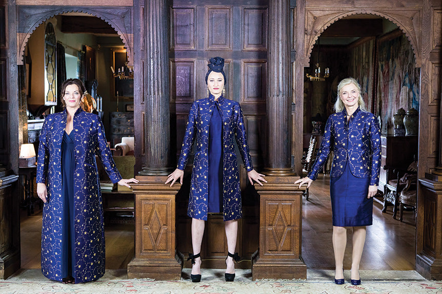 Three women of different body shapes all in navy blue silk dresses and coats