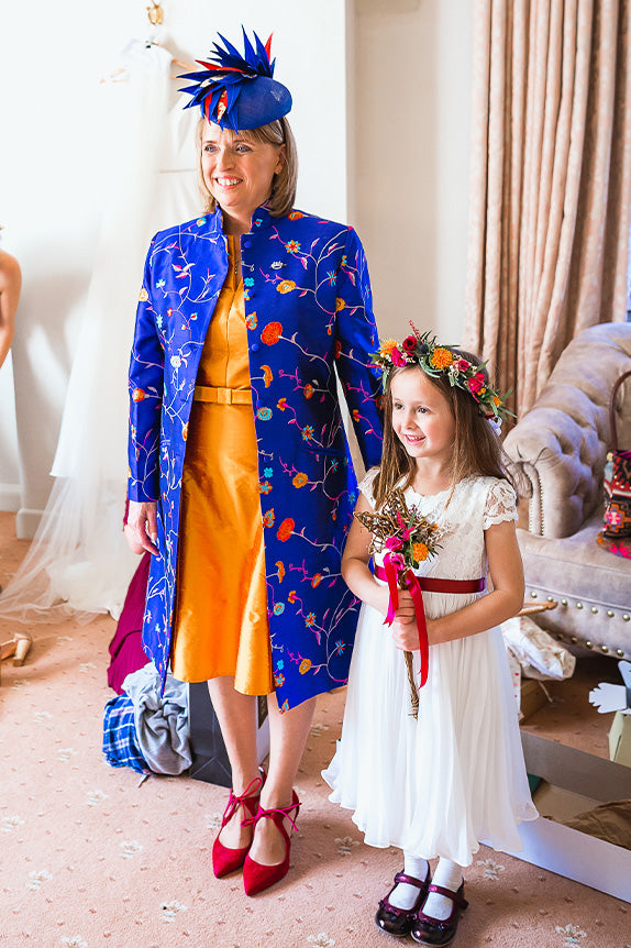 Mother of the bride with flower girl, mother of the bride in orange dress with blue shibumi nehru coat in african cobalt