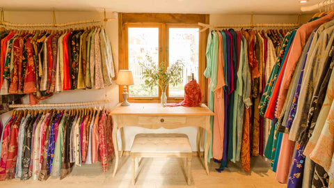 A photo of the Shibumi Showroom showing silk and cashmere wedding outfits in their wooden cabin.